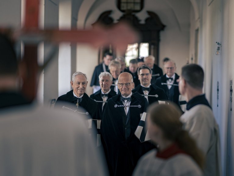 Die Patres gehen lächelnd in einer Prozession