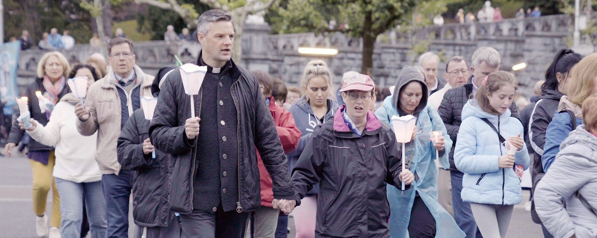 Pater Jörg bei einem Umzug mit Kerzen am frühen Abend