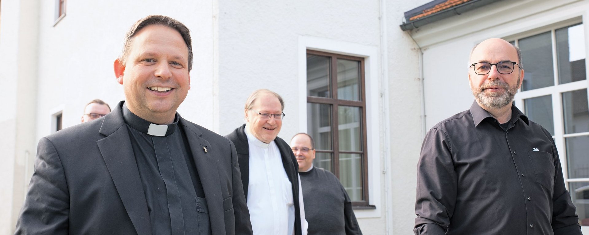 Pater lächelt in Kamera